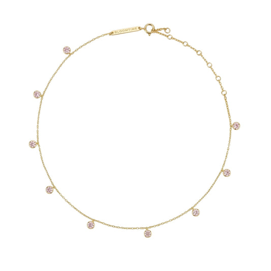 A delicate gold chain necklace with multiple small, round pink gemstone clusters spaced evenly along the chain, displayed on a clean white background.