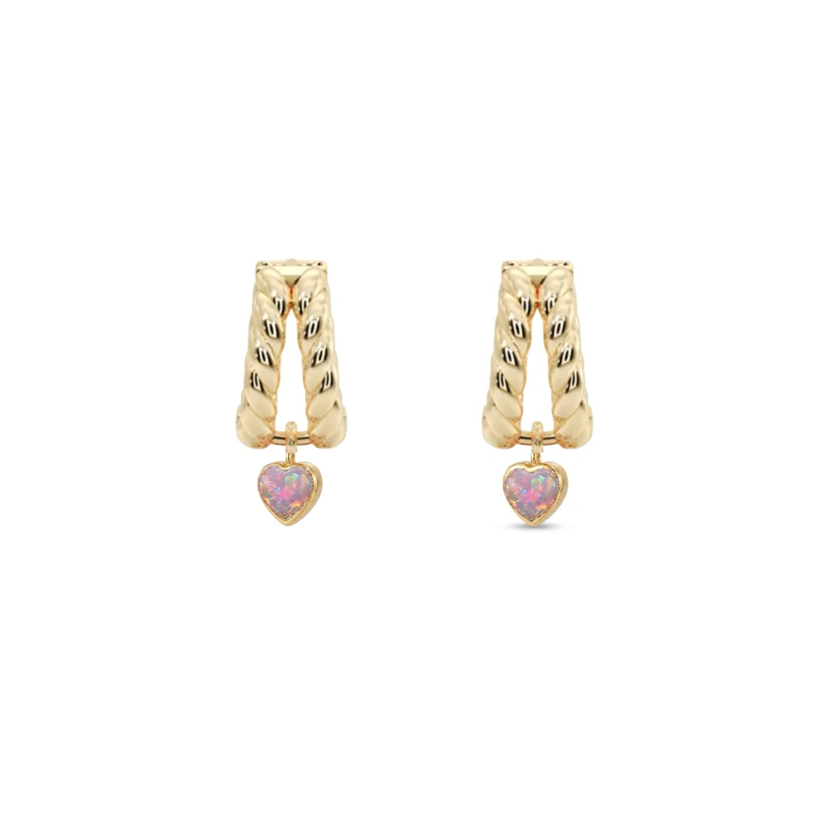 A pair of gold huggie hoop earrings with textured vertical bars and a small dangling pink heart charm, shown on a plain white background.