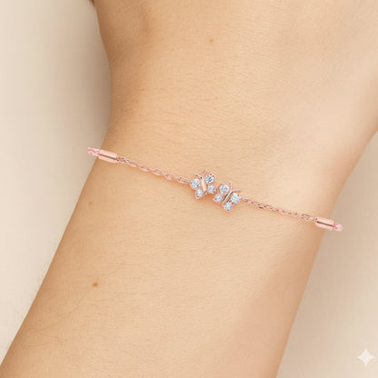 Rose gold bracelet with small diamonds on a wrist against a beige background