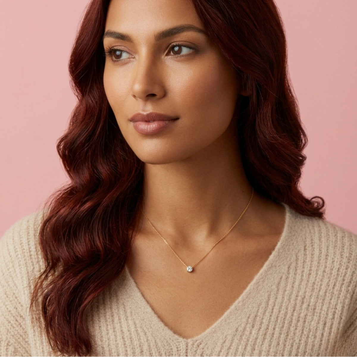 Close-up of a delicate BLOOMTINE gold pendant necklace on a model. This minimalist goddess-inspired accessory features a small, captivating charm on a fine gold-over-silver chain, demonstrating tarnish-resistant everyday luxury against a soft neutral backdrop